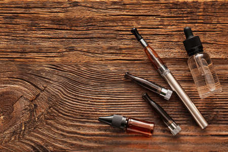 Electronic cigarette with oil on wooden backgroundの写真素材