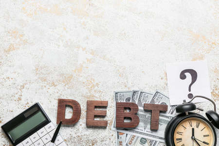 Word DEBT with calculator, money and alarm clock on grunge background