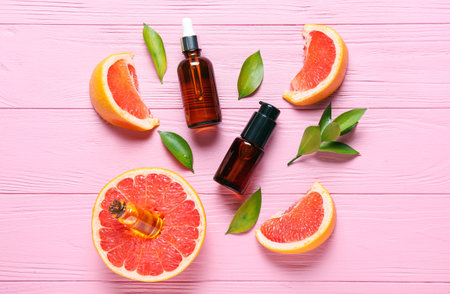 Composition with bottles of essential oil and grapefruit slices on color wooden backgroundの写真素材