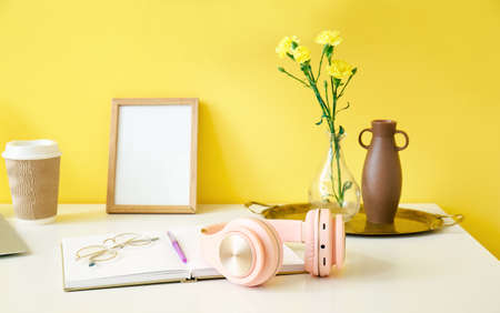 Modern workplace with headphones near color wallの写真素材
