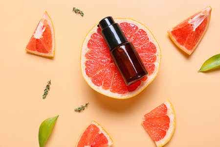 Composition with bottle of essential oil and grapefruit on color backgroundの写真素材