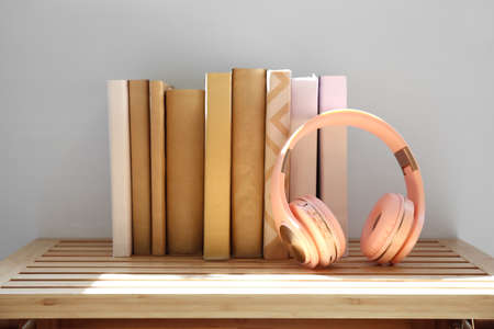 Headphones with books on shelf near light wallの写真素材