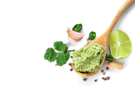 Spoon with tasty guacamole, lime and garlic on white backgroundの写真素材