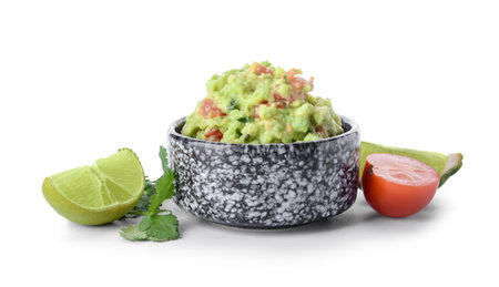Bowl with tasty guacamole, lime and tomato on white backgroundの写真素材