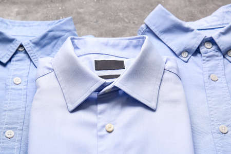 Stylish male shirts on grunge background, closeup