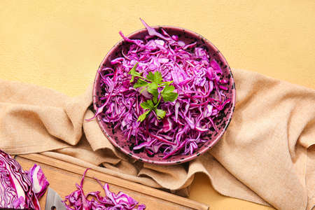 Bowl with cut fresh purple cabbage and parsley on color backgroundの写真素材