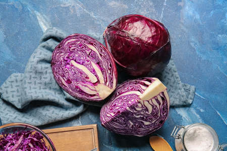 Pieces of fresh purple cabbage on color background
