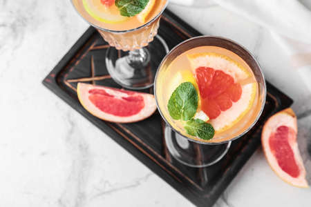 Glasses of tasty grapefruit cocktail on light background, closeupの写真素材