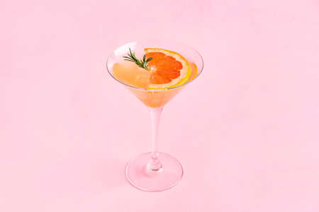 Glass of tasty grapefruit cocktail on color background