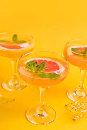 Glasses of tasty grapefruit cocktail on color backgroundの写真素材