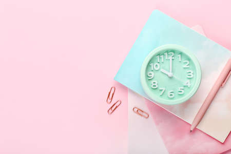 Stylish alarm clock and stationery on color backgroundの写真素材