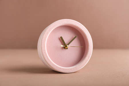 Stylish alarm clock on color background