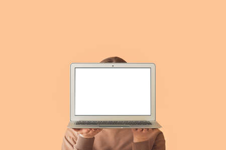 Young woman holding laptop with blank screen on color background