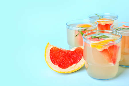 Glasses of tasty grapefruit lemonade on color background