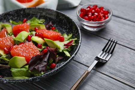 Plate with tasty grapefruit salad on dark wooden backgroundの写真素材