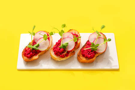 Tasty bruschettas with radish on color background