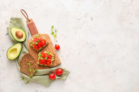 Tasty bruschettas with tomato and guacamole on light background
