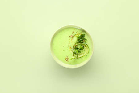 Bowl with green gazpacho on color backgroundの写真素材