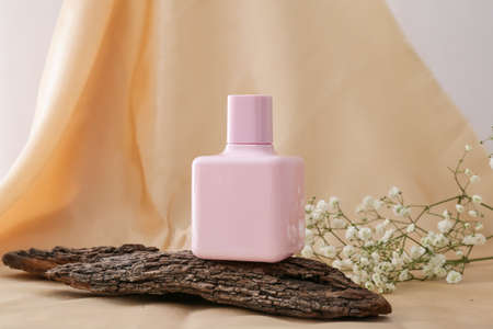 Composition with bottle of perfume on color cloth background