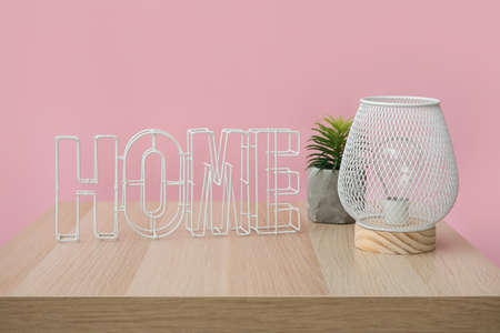Stylish lamp with decor on table near color wallの写真素材