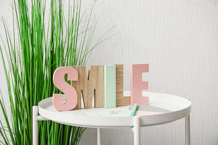 Stylish decor on table near light wall