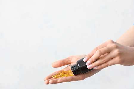woman taking pills on light backgroundの写真素材