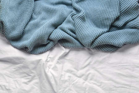 Knitted plaid on bed, closeup
