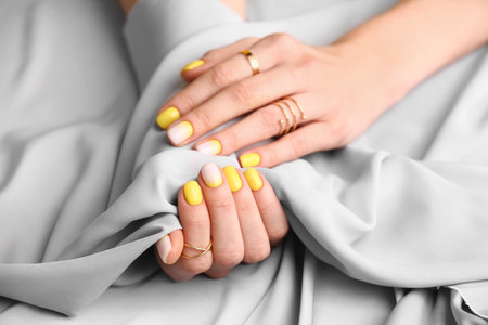 Female hands with beautiful manicure and fabric, closeupの写真素材