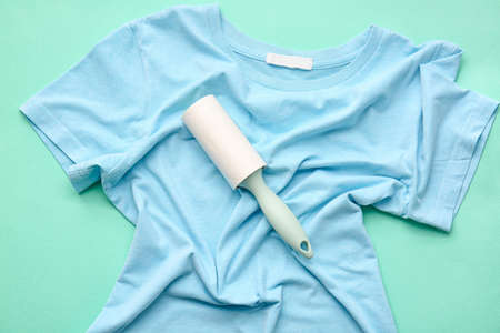 Lint roller and t-shirt on color background, closeupの写真素材
