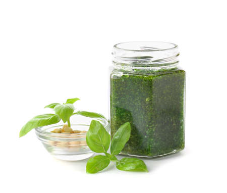 Jar with fresh pesto sauce and ingredients on white backgroundの写真素材