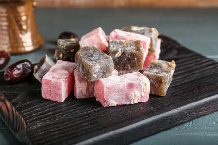 Board with sweet Turkish delight on gray wooden background