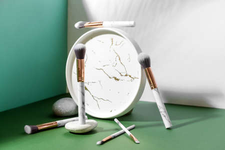 Set of makeup brushes with decor on color background