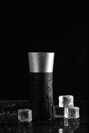 Bottle of perfume and ice cubes on dark backgroundの写真素材