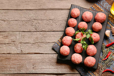 Composition with raw cutlets made of fresh forcemeat on wooden backgroundの写真素材