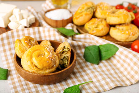 Puff pastry stuffed with spinach on light background