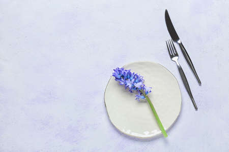 Beautiful table setting and hyacinth flower on light background
