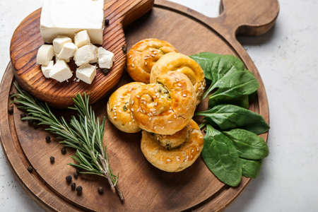 Puff pastry stuffed with spinach, feta cheese and herbs on light backgroundの写真素材