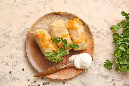 Plate with tasty stuffed cabbage rolls on grunge background