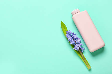 Bottle of cosmetic product and beautiful hyacinth flower on color backgroundの写真素材