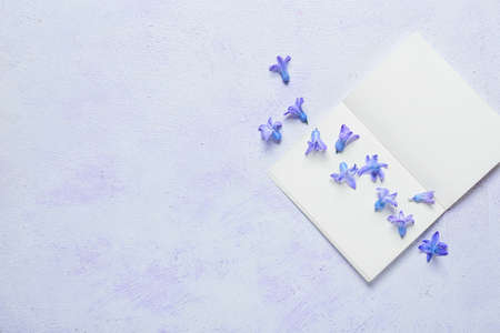 Beautiful hyacinth flowers and blank notebook on light backgroundの写真素材