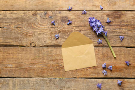 Beautiful hyacinth flower and blank envelope on wooden backgroundの写真素材