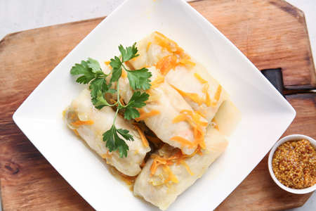 Plate with tasty stuffed cabbage rolls on wooden backgroundの写真素材