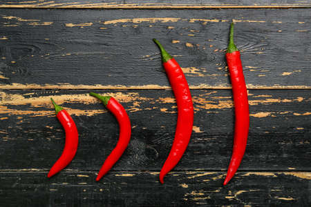 Hot chili peppers on dark wooden backgroundの写真素材