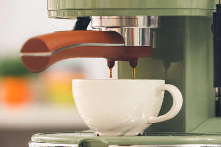 Preparing fresh espresso with coffee machine in kitchenの写真素材