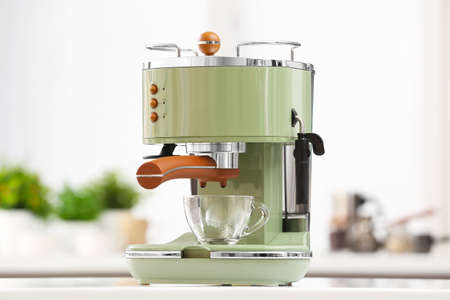 Preparing fresh espresso with coffee machine on table in kitchenの写真素材