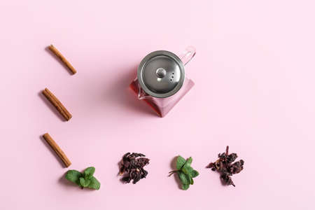 Composition of teapot with tasty tea and spices on pink backgroundの写真素材
