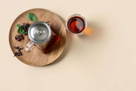 Teapot and glass of tasty tea on yellow backgroundの写真素材