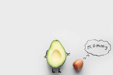 Creative composition with half avocado and speech bubble with text MAMMY on light backgroundの写真素材