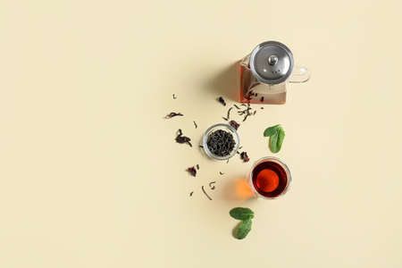 Composition of teapot and glass with tasty tea on yellow backgroundの写真素材