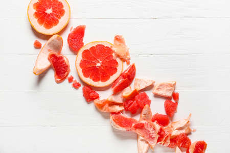 Tasty grapefruit pieces on light wooden backgroundの写真素材